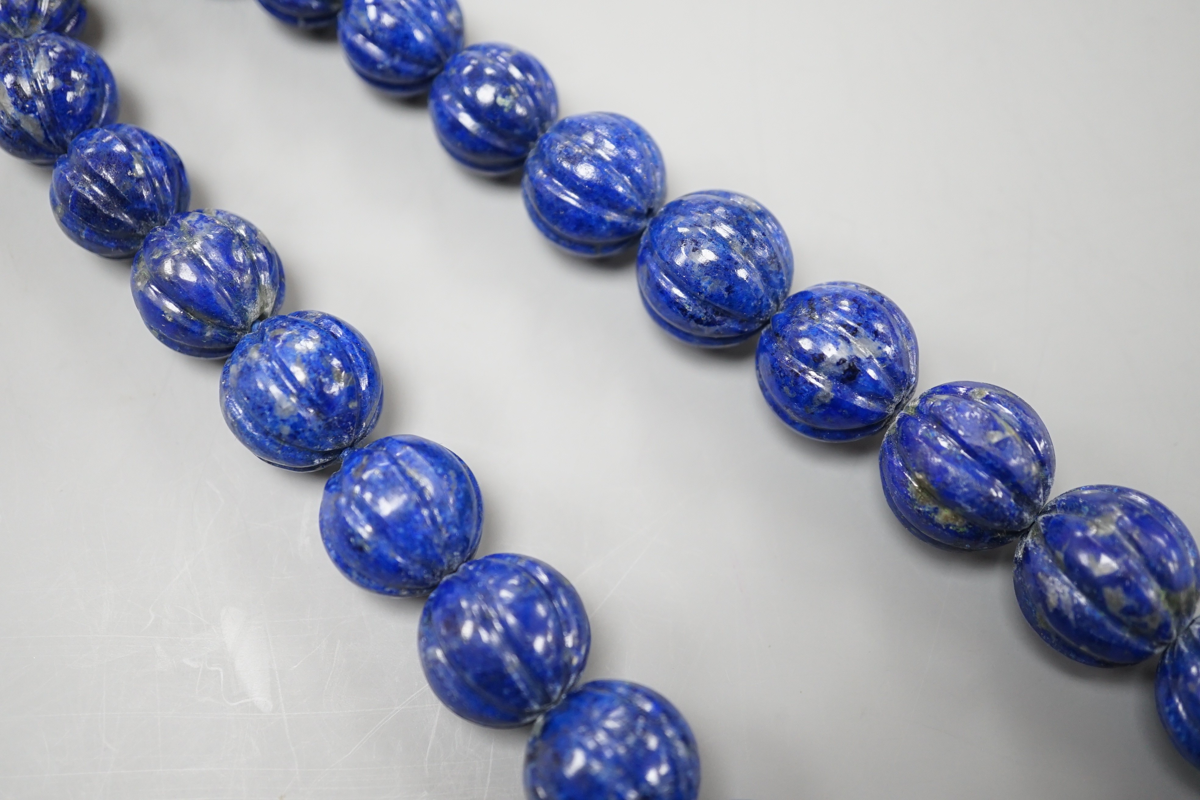 A single strand graduated fluted lapis lazuli bead necklace, 44cm